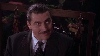 Movie still from “Chocolat” (2000), directed by Lasse Hallström – A man with a mustache wearing a suit; Close Up shot, Low angle