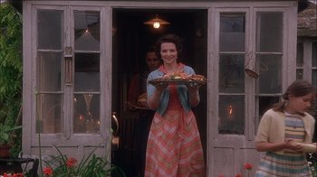 Movie still from “Chocolat” (2000), directed by Lasse Hallström – A woman holding a tray in front of a door; Medium shot, Low angle