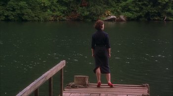 Movie still from “Chocolat” (2000), directed by Lasse Hallström – A woman standing on a dock looking out at the water; Wide shot, High angle