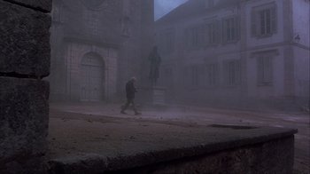 Movie still from “Chocolat” (2000), directed by Lasse Hallström – A man walking down the street in the fog; Extreme Wide shot, High angle