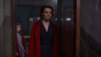Movie still from “Chocolat” (2000), directed by Lasse Hallström – A woman in a blue dress and a red coat; Medium shot, Over the shoulder angle