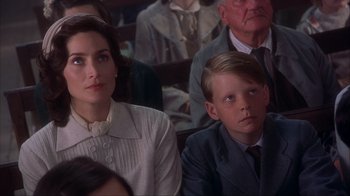 Movie still from “Chocolat” (2000), directed by Lasse Hallström – A woman sitting next to a boy in a crowd; Close Up shot, High angle