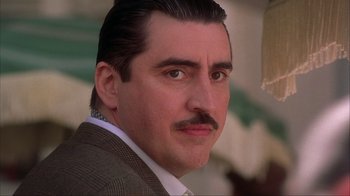 Movie still from “Chocolat” (2000), directed by Lasse Hallström – A person wearing a suit and mustache; Close Up shot, Low angle