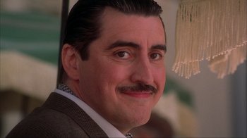 Movie still from “Chocolat” (2000), directed by Lasse Hallström – A person wearing a suit and tie; Close Up shot, Low angle