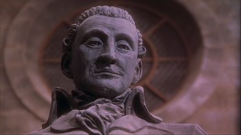 Movie still from “Chocolat” (2000), directed by Lasse Hallström – A statue of a man with a beard; Close Up shot, Low angle