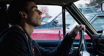 Movie still from “Chronicle” (2012), directed by Josh Trank – A man driving a car in the rain; Close Up shot, Low angle