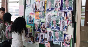 Movie still from “Chronicle” (2012), directed by Josh Trank – A wall covered with pictures of people with different faces; Medium shot, High angle
