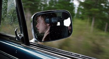 Movie still from “Chronicle” (2012), directed by Josh Trank – A man's reflection in the side mirror of a car; Close Up shot, Over the shoulder angle
