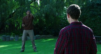 Movie still from “Chronicle” (2012), directed by Josh Trank – Two men are playing frisbee in a yard; Medium shot, Over the shoulder angle