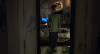 Movie still from “Chronicle” (2012), directed by Josh Trank – A man standing in front of a mirror in a room; Wide shot, Overhead angle