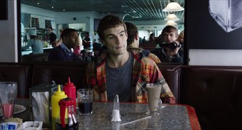 Movie still from “Chronicle” (2012), directed by Josh Trank – A man sitting at a table in front of a cup of coffee; Medium shot, Over the shoulder angle