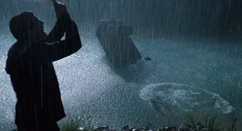 Movie still from “Chronicle” (2012), directed by Josh Trank – A person taking a picture in the rain; Wide shot, Low angle