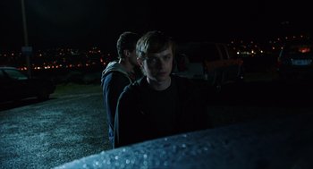 Movie still from “Chronicle” (2012), directed by Josh Trank – Two young men standing next to each other in a parking lot at night; Medium shot, Over the shoulder angle