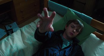 Movie still from “Chronicle” (2012), directed by Josh Trank – A man laying in a bed holding his hand up; Medium shot, Overhead angle