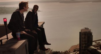 Movie still from “Chronicle” (2012), directed by Josh Trank – Two men are sitting on a ledge overlooking the water; Wide shot, High angle