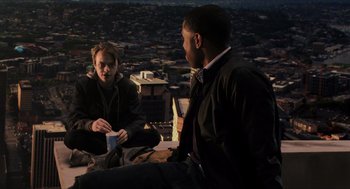 Movie still from “Chronicle” (2012), directed by Josh Trank – Two people are sitting on a ledge and one of them is holding a coffee cup; Medium shot, Over the shoulder angle