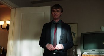 Movie still from “Chronicle” (2012), directed by Josh Trank – A man in a suit and tie holding a cell phone; Medium shot, Over the shoulder angle