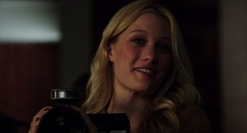 Movie still from “Chronicle” (2012), directed by Josh Trank – A beautiful blond woman holding a camera in a dark room; Close Up shot, Over the shoulder angle