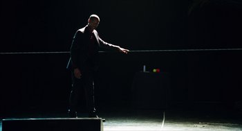 Movie still from “Chronicle” (2012), directed by Josh Trank – A man in a suit and tie standing in a dark room; Wide shot, High angle