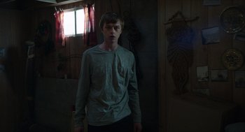 Movie still from “Chronicle” (2012), directed by Josh Trank – A young man standing in a room with a window in the background; Medium shot, Over the shoulder angle