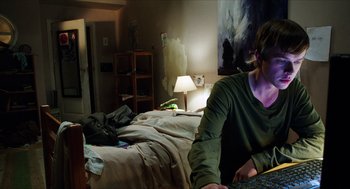 Movie still from “Chronicle” (2012), directed by Josh Trank – A man sitting in a bedroom next to a messy bed; Medium shot, Over the shoulder angle