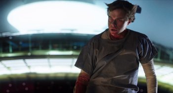 Movie still from “Chronicle” (2012), directed by Josh Trank – A man in a hospital gown and bandages on his arm; Medium shot, Low angle