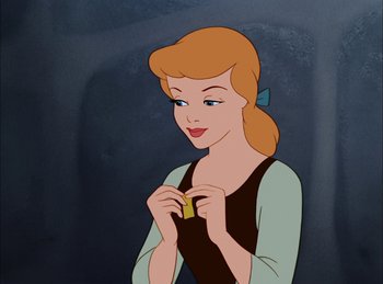 Movie still from “Cinderella” (1950), directed by Hamilton Luske – A woman holding a banana in front of a dark background; Close Up shot, High angle