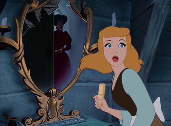 Movie still from “Cinderella” (1950), directed by Hamilton Luske – A woman in front of a mirror with a knife in her mouth; Medium shot, Over the shoulder angle