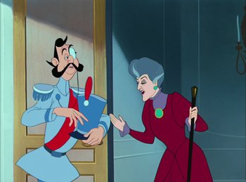 Movie still from “Cinderella” (1950), directed by Hamilton Luske – An old lady is pointing at a man in a blue suit; Medium shot, Over the shoulder angle