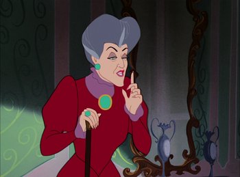 Movie still from “Cinderella” (1950), directed by Hamilton Luske – A woman in a red dress holding a cane; Close Up shot, Over the shoulder angle
