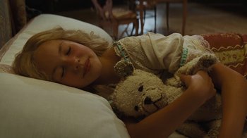 Movie still from “Cinderella” (2015), directed by Kenneth Branagh – A young girl is sleeping with a teddy bear; Close Up shot, High angle