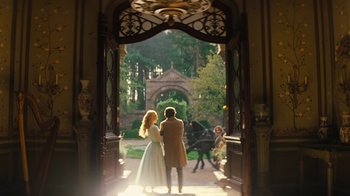 Movie still from “Cinderella” (2015), directed by Kenneth Branagh – A man and a woman standing in front of an archway; Wide shot, Low angle