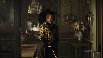 Movie still from “Cinderella” (2015), directed by Kenneth Branagh – A woman in a yellow and black dress holding a black umbrella; Medium shot, Low angle
