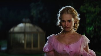 Movie still from “Cinderella” (2015), directed by Kenneth Branagh – A woman in a pink dress standing in front of a gazebo at night; Close Up shot, Over the shoulder angle