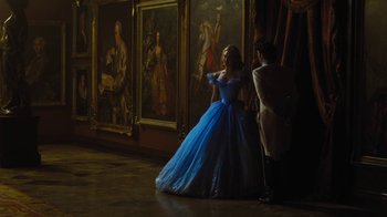 Movie still from “Cinderella” (2015), directed by Kenneth Branagh – A woman in a blue dress standing next to a man in a white suit; Wide shot, Over the shoulder angle