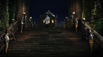 Movie still from “Cinderella” (2015), directed by Kenneth Branagh – A man standing on some steps in front of a building; Extreme Wide shot, Low angle