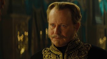 Movie still from “Cinderella” (2015), directed by Kenneth Branagh – A person with a beard and mustache; Close Up shot, Over the shoulder angle