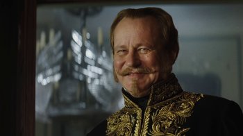 Movie still from “Cinderella” (2015), directed by Kenneth Branagh – A person with a mustache wearing a suit; Close Up shot, Low angle