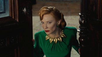 Movie still from “Cinderella” (2015), directed by Kenneth Branagh – A woman in a green dress with a gold necklace; Close Up shot, Over the shoulder angle