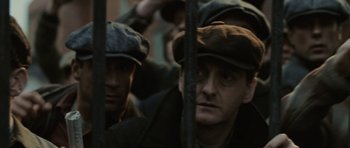 Movie still from “Cinderella Man” (2005), directed by Ron Howard – A group of men wearing hats looking through a fence; Close Up shot, High angle