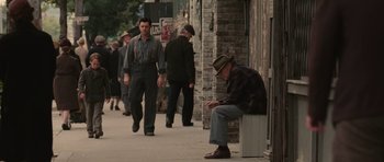 Movie still from “Cinderella Man” (2005), directed by Ron Howard – An old man sitting on the side of the street; Wide shot, Over the shoulder angle