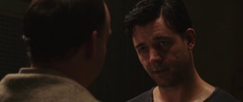 Movie still from “Cinderella Man” (2005), directed by Ron Howard – A man looking at another man in a dark room; Close Up shot, Over the shoulder angle