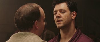 Movie still from “Cinderella Man” (2005), directed by Ron Howard – Two men are talking to each other in a dark room; Close Up shot, Over the shoulder angle