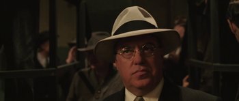 Movie still from “Cinderella Man” (2005), directed by Ron Howard – An older man wearing a hat and glasses; Close Up shot, Over the shoulder angle