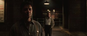 Movie still from “Cinderella Man” (2005), directed by Ron Howard – Two men standing next to each other in the dark; Medium shot, Over the shoulder angle
