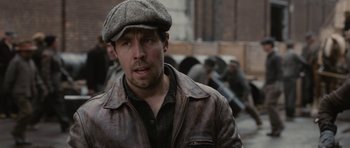 Movie still from “Cinderella Man” (2005), directed by Ron Howard – A man wearing a leather jacket and a hat; Close Up shot, Over the shoulder angle