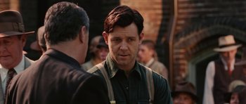 Movie still from “Cinderella Man” (2005), directed by Ron Howard – A person wearing suspenders near a brick wall; Close Up shot, Over the shoulder angle
