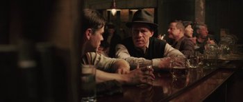 Movie still from “Cinderella Man” (2005), directed by Ron Howard – Two men sitting at a table talking to each other; Medium shot, Over the shoulder angle
