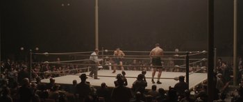 Movie still from “Cinderella Man” (2005), directed by Ron Howard – A boxing match in a boxing ring with spectators watching; Extreme Wide shot, High angle