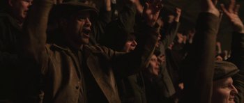 Movie still from “Cinderella Man” (2005), directed by Ron Howard – A group of people standing in a room with their hands up; Medium shot, Low angle